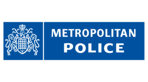 Metropolitan Police logo featuring a white crest with two lions on a blue background beside the words Metropolitan Police in bold white letters, as seen in 2024 during Laurence Taylor’s term of office.