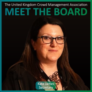 Woman with long dark hair and glasses posed in front of a black background. Text reads: MEET THE BOARD MEMBERS, Kate James, Secretary, The United Kingdom Crowd Management Association.