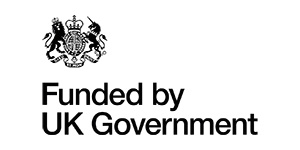 Black text reads Funded by UK Government next to a black-and-white UK government crest featuring a lion, crown, and unicorn on a white background—a commitment towards safer crowds and safer venues by 2026.
